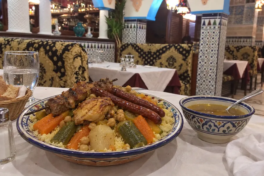 Couscous servi en salle, sous les colonnes de zellige
