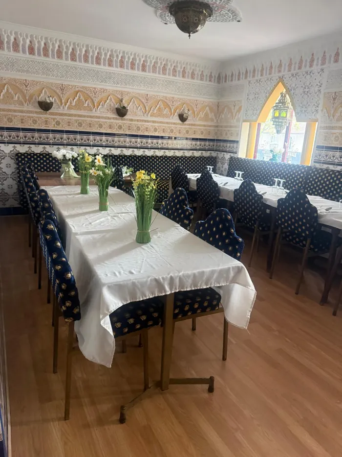 Longue table dressée pour un groupe, nappes blanches et fleurs